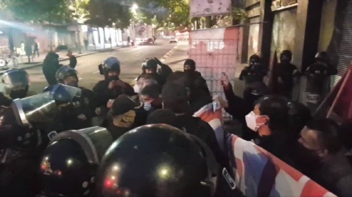 Policías encapsulan a extrabajadores de Notimex durante una manifestación frente a Palacio