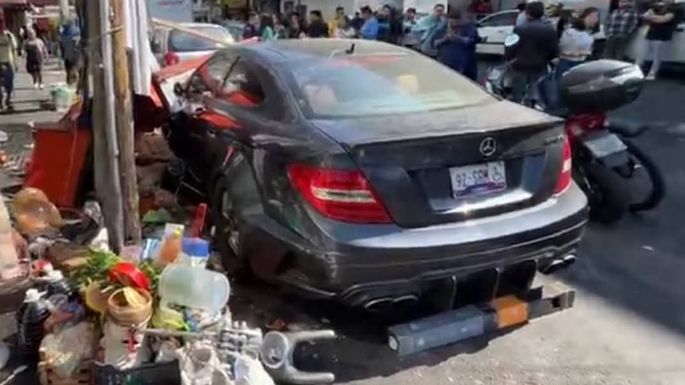 Joven choca su Mercedes Benz contra puestos de comida