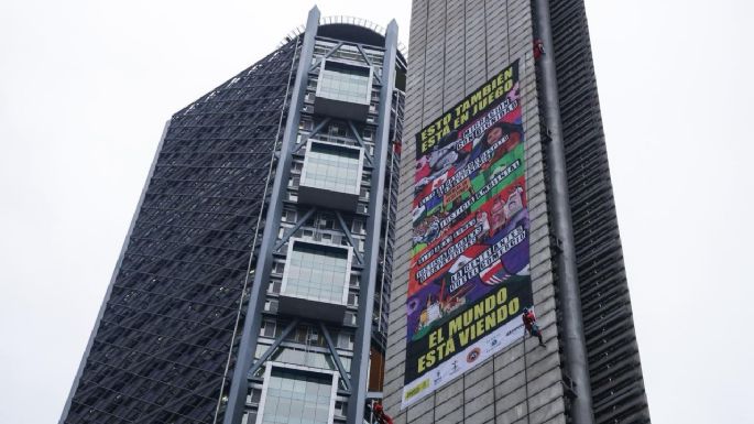 Greenpeace, Amnistía y más de 100 ONG despliegan lona en Estela de Luz; piden encuentro con Sheinbaum