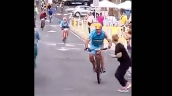 Ciclista arrolla en una carrera a una espectadora que cruzó distraída (Video)