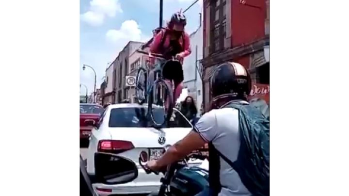 Mujer ciclista pasa por encima de un auto que invadió ciclovía en Querétaro