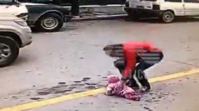 Captan cómo un hombre salva a bebé que cruzaba una calle gateando