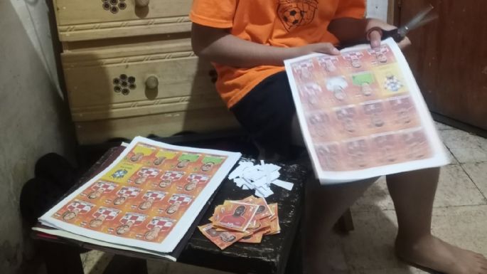 Un padre saca copias a las estampas del álbum Panini para que su hijo pueda llenarlo