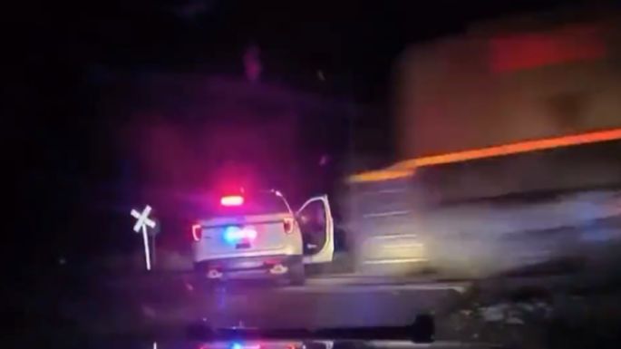 Policía detiene a una mujer, la sube a una patrulla y la arrolla un tren de carga (Video)