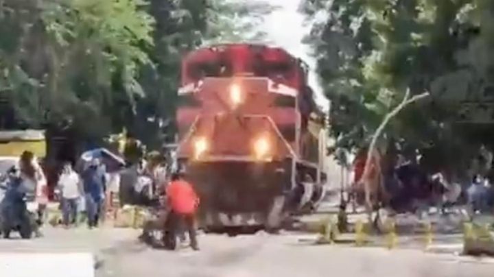 Tres personas salvan a un hombre en silla de ruedas de ser arrollado por el tren (Video)
