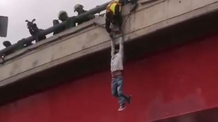 Un hombre intenta lanzarse de un puente, lo disuaden y cae en el intento de rescatarlo